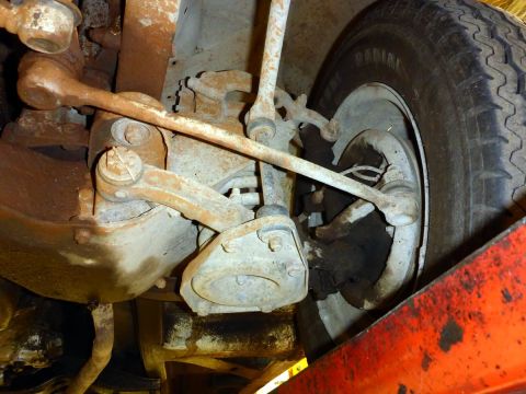 1962 MG B - Close-up of aged suspension components and a tire, showing wear and rust.