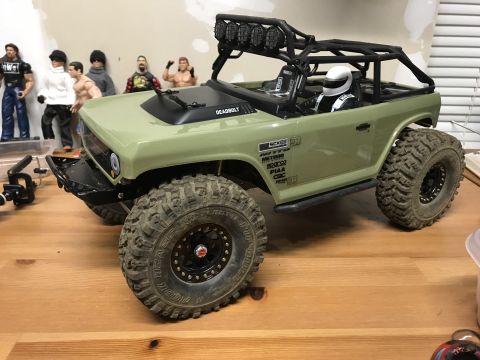 1989 Ford Bronco - This RC rock crawler features a detailed interior, roll cage, and aggressive off-road tires, resembling a modified off-road vehicle.