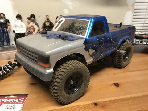 1989 Ford Bronco - This RC truck features a silver hood and blue flame decals on its side, with a number '1' on the windshield.
