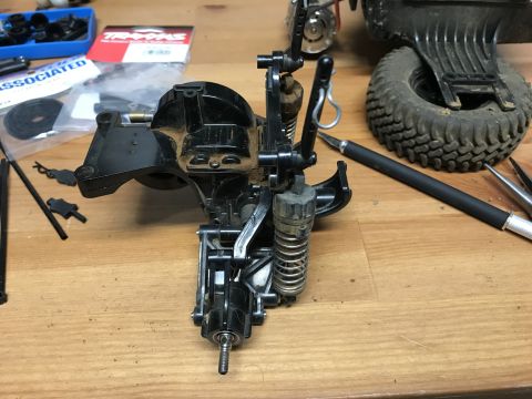 1989 Ford Bronco - RC car parts and tools are laid out on a workbench, ready for assembly or repair.