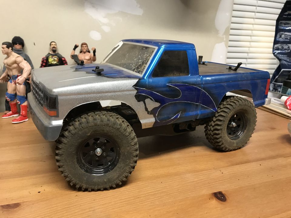Silver and blue remote control truck with flame decals and large tires