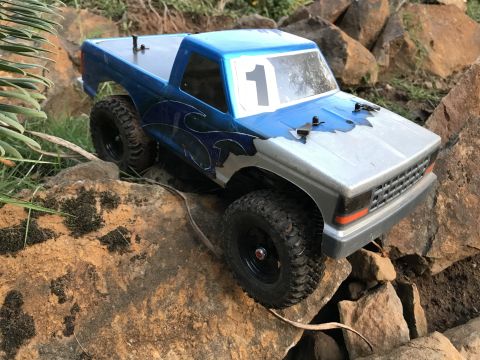1989 Ford Bronco - This remote-controlled truck is navigating a rocky terrain, showing off its off-road capabilities.