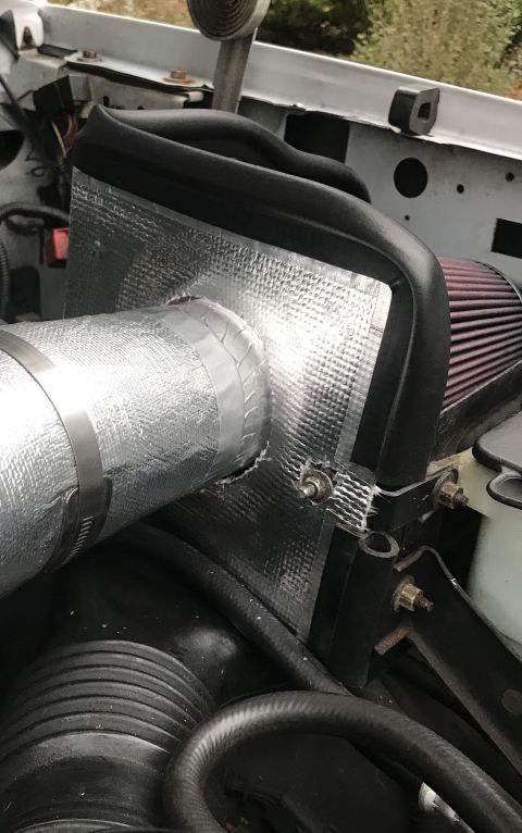 1995 Ford Bronco - Close-up of an engine bay, focusing on an upgraded air intake system with heat shielding.