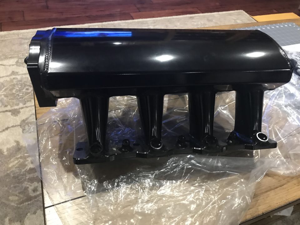 Black aftermarket intake manifold with four runners