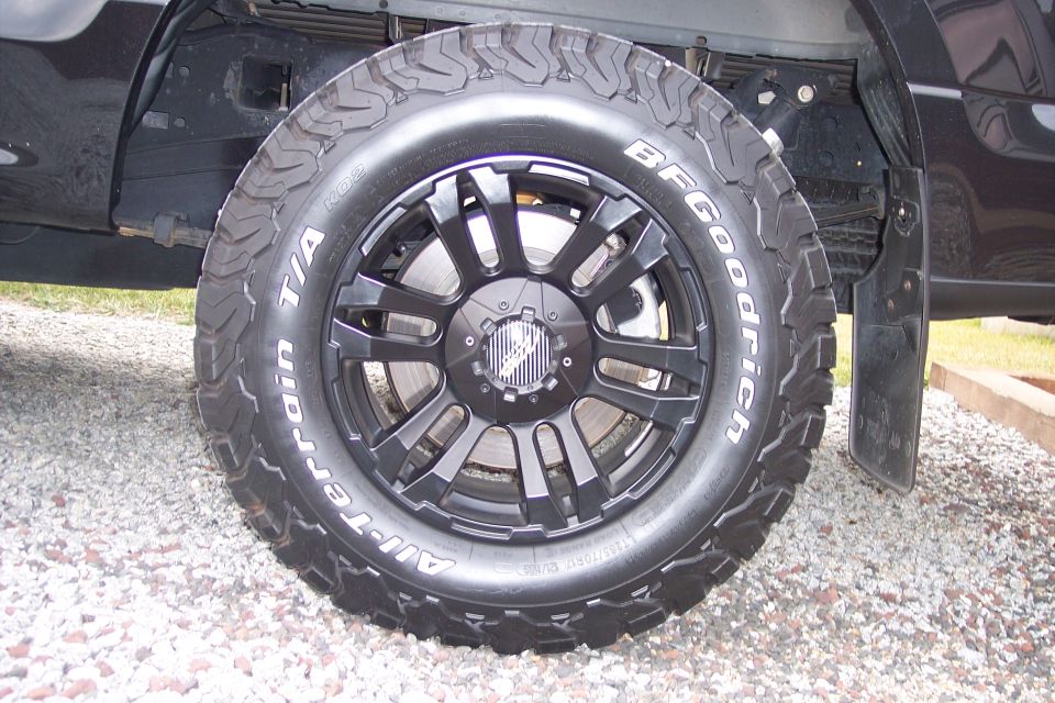 Black pickup truck BFGoodrich All-Terrain T/A KO2 tire on black aftermarket wheel.