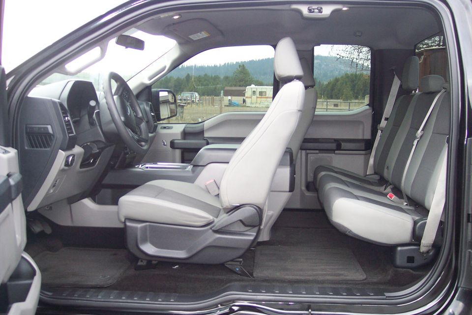 Interior of a black Ford F-150 pickup truck, showing front and rear seats.