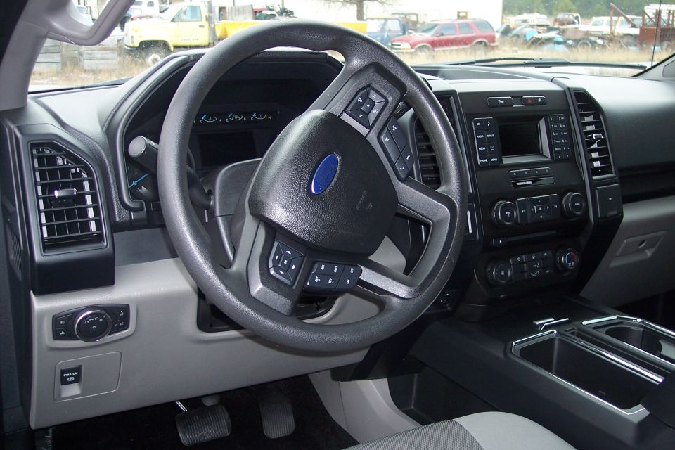 Interior of a Ford F-150 pickup truck, showing the steering wheel, dashboard, and center console.
