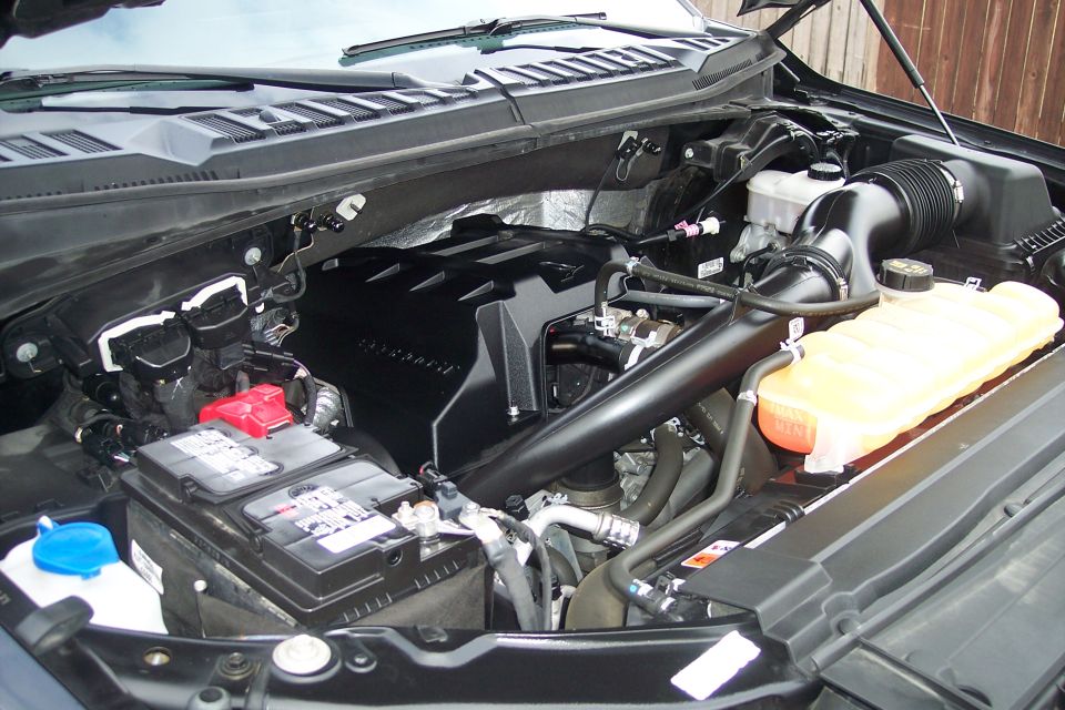 2015 Ford F-150 engine bay with V6 cover, battery, and air intake