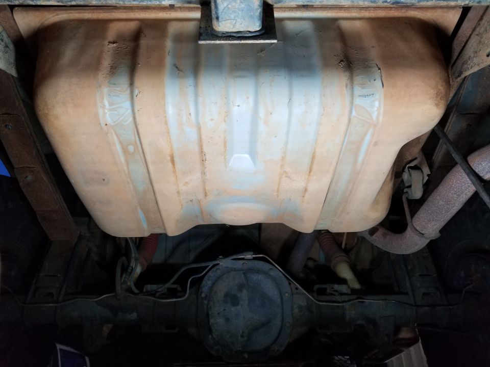 underside view of a vehicle showing the fuel tank, differential, and exhaust system