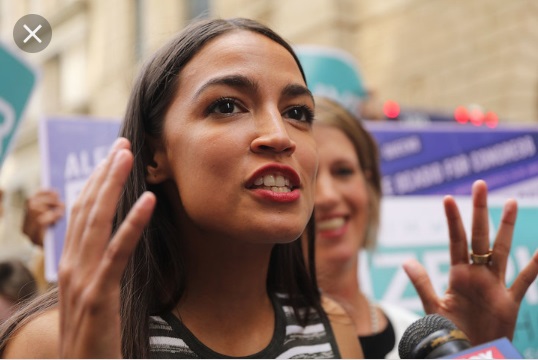Woman speaking into a microphone with another woman behind her.