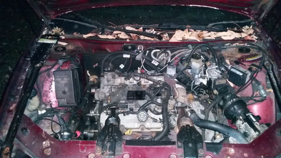 Engine bay of a maroon 2000 Pontiac Grand Prix