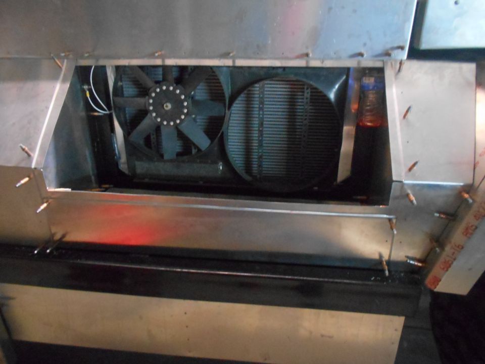 Vehicle cooling system with dual fans and radiator inside a custom metal enclosure.
