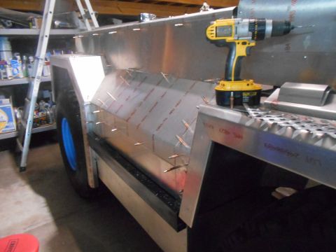 1992 Ford Bronco - A yellow and black DeWalt cordless drill is positioned above a metal panel being attached to a vehicle's body, likely a fender or side pane…