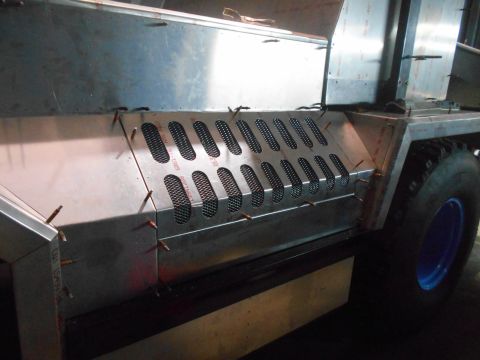 1992 Ford Bronco - A close-up, side view of a custom metal fabrication project on a vehicle, featuring a panel with multiple oval-shaped vents covered by mesh…
