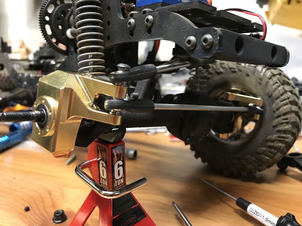 Close-up of brass axle housing and suspension on an off-road vehicle part.