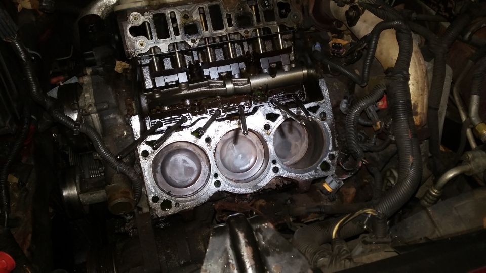 Engine block of a 2000 Pontiac Grand Prix with cylinder head removed, showing pistons and cylinders.