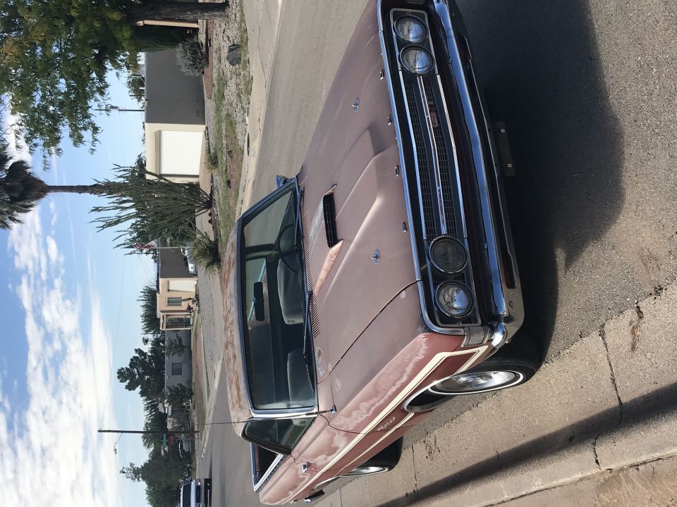 Pink 1969 Ford Ranchero front view, parked on a street.