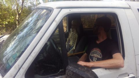 1996 Ford Bronco - A person wearing a black t-shirt with a Brooklyn Nets logo sits in the driver's seat of a white Ford Bronco, looking out the open window. A…