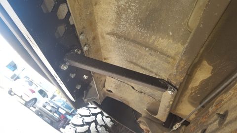1995 Ford Bronco - Aftermarket rock sliders installed on the underbody of a vehicle, with other vehicles in the background.