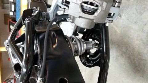 1970 Chevrolet Camaro - A close-up view of a vehicle's suspension system, showing a coilover shock absorber and brake caliper.