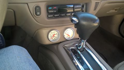2004 Ford Crown Victoria - Aftermarket gauges are installed below the climate controls and next to the automatic gear shifter.