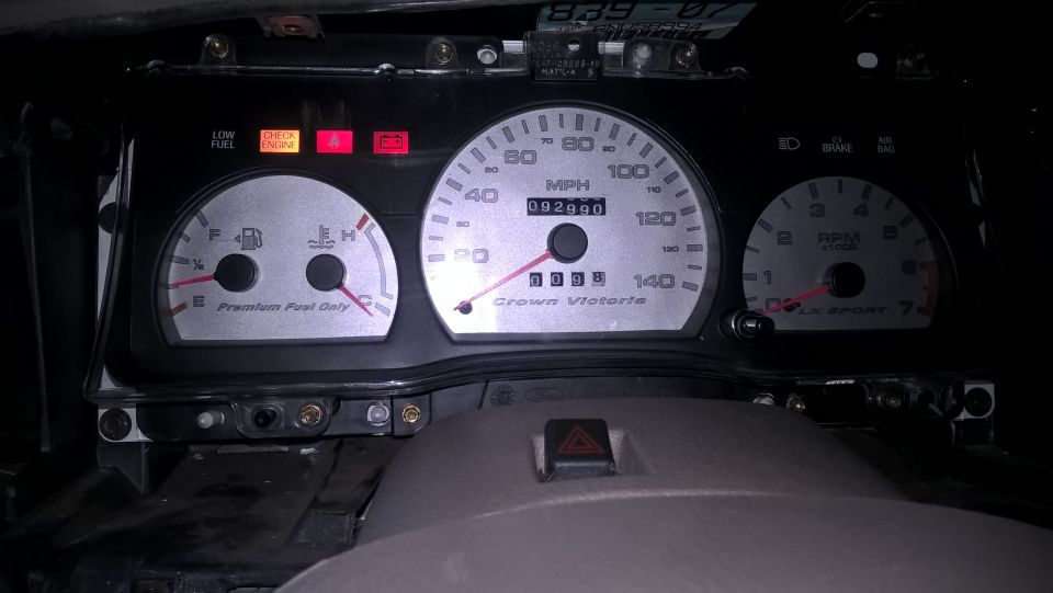Car dashboard with speedometer, fuel gauge, and tachometer. Odometer reads 092990