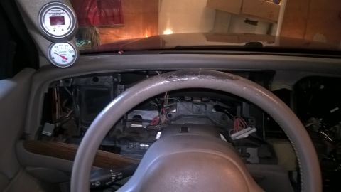 2004 Ford Crown Victoria - Aftermarket gauges are installed on the dashboard, with wiring exposed around the steering column.
