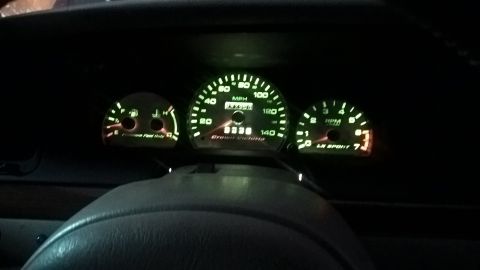 2004 Ford Crown Victoria - The illuminated dashboard gauges of a 2004 Ford Crown Victoria are visible, displaying speed, RPM, and fuel levels.