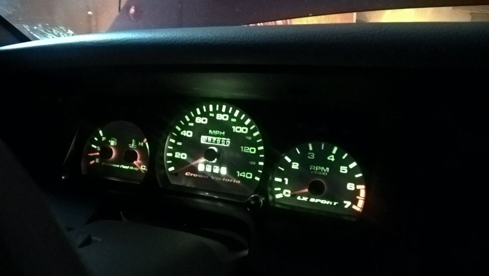 Interior view of 2004 Ford Crown Victoria dashboard gauges with illuminated speedometer and tachometer