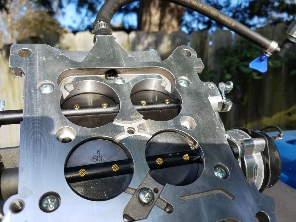 Close-up of a four-barrel carburetor with visible markings