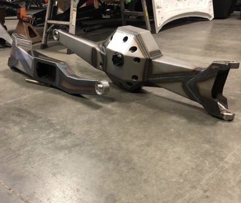 1979 Ford Bronco - Custom suspension parts are shown on a concrete floor in a workshop setting.