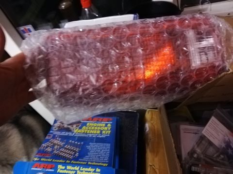 1996 Ford Bronco - A red taillight assembly, still in bubble wrap, sits near boxes of ARP engine and accessory fastener kits.
