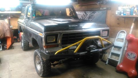 1978 Ford Bronco - Front view of a 1978 Ford Bronco in a garage, modified with a bull bar and winch.