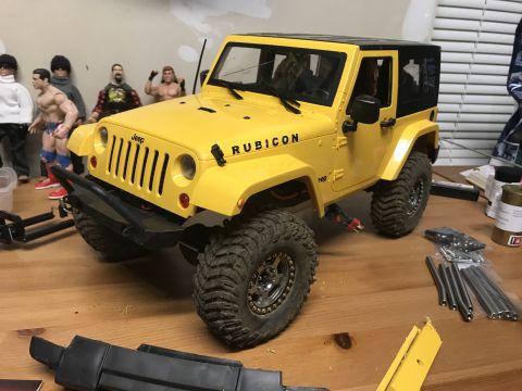 1989 Ford Bronco - RC Jeep Wrangler Rubicon model with action figures in the background.
