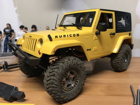 1989 Ford Bronco - This yellow Jeep Wrangler Rubicon features prominent "Rubicon" badging on the hood and "Jeep" badging on the fender.