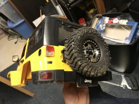 1989 Ford Bronco - Toy Jeep Wrangler rear view, showing spare tire and 'Jeep' logo on bumper.