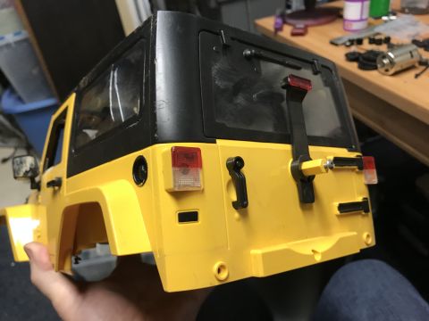 1989 Ford Bronco - This is a yellow RC car body, resembling a Jeep Wrangler, being held up for inspection.