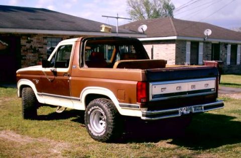 1980 Ford Bronco - Brown and white 1980 Ford Bronco parked in front of a house.
