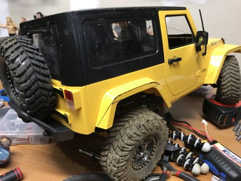 1989 Ford Bronco - A remote-controlled Jeep Wrangler sits on a table with various tools and electronic components nearby.