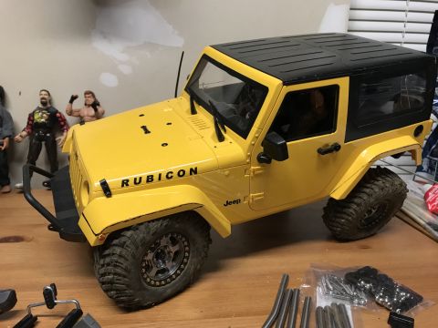 1989 Ford Bronco - A remote-controlled Jeep Wrangler sits on a table, surrounded by parts and action figures.