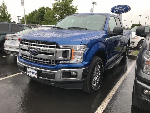 2018 Ford F-150 - A blue Ford F-150 pickup truck is parked in a lot with other vehicles visible.