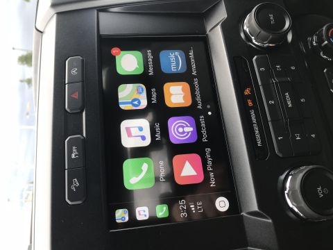 2018 Ford F-150 - Close-up of a car's infotainment system displaying various app icons and playback controls.