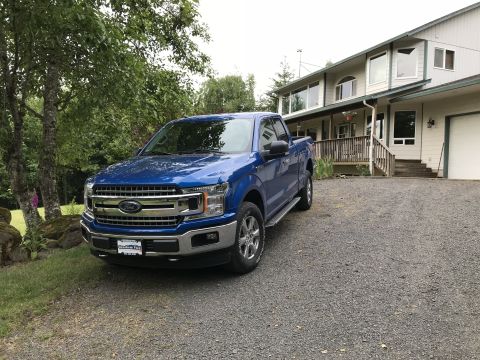 2018 Ford F-150 - A blue 2018 Ford F-150 pickup truck is parked in front of a house.