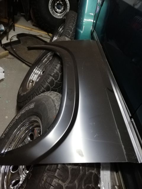 1996 Ford Bronco - A new fender flare and several tires are stored indoors, possibly for a Ford Bronco.