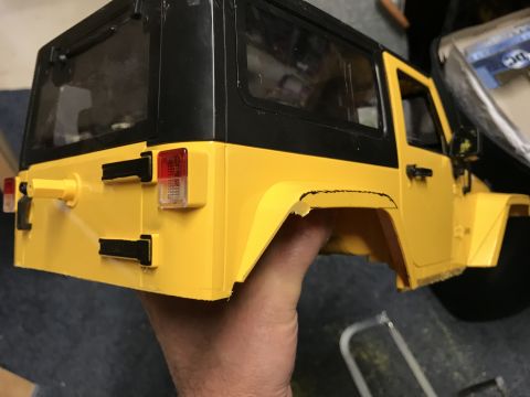 1989 Ford Bronco - A yellow toy Jeep body is shown from the rear quarter, held by a hand.