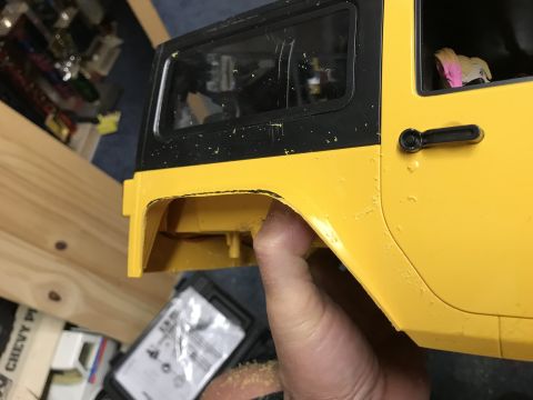 1989 Ford Bronco - Close-up of a yellow and black toy vehicle body, revealing details of its construction.