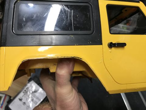 1989 Ford Bronco - Close-up of a yellow and black toy car body, showing the side panel and window detail.