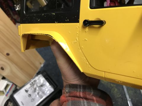 1989 Ford Bronco - Close-up of a yellow toy jeep door, showing chipped paint and a black door handle.