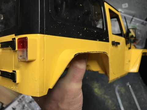 1989 Ford Bronco - A yellow toy jeep body with a black hardtop is held by a hand, showing its rear section.