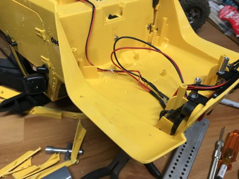 1989 Ford Bronco - The interior of a yellow RC car chassis is shown, with wiring and some disassembled parts visible.